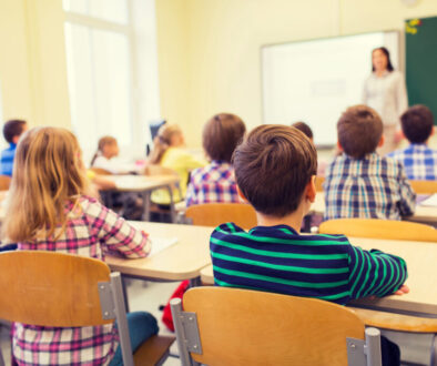 group of school kids and teacher in classroom